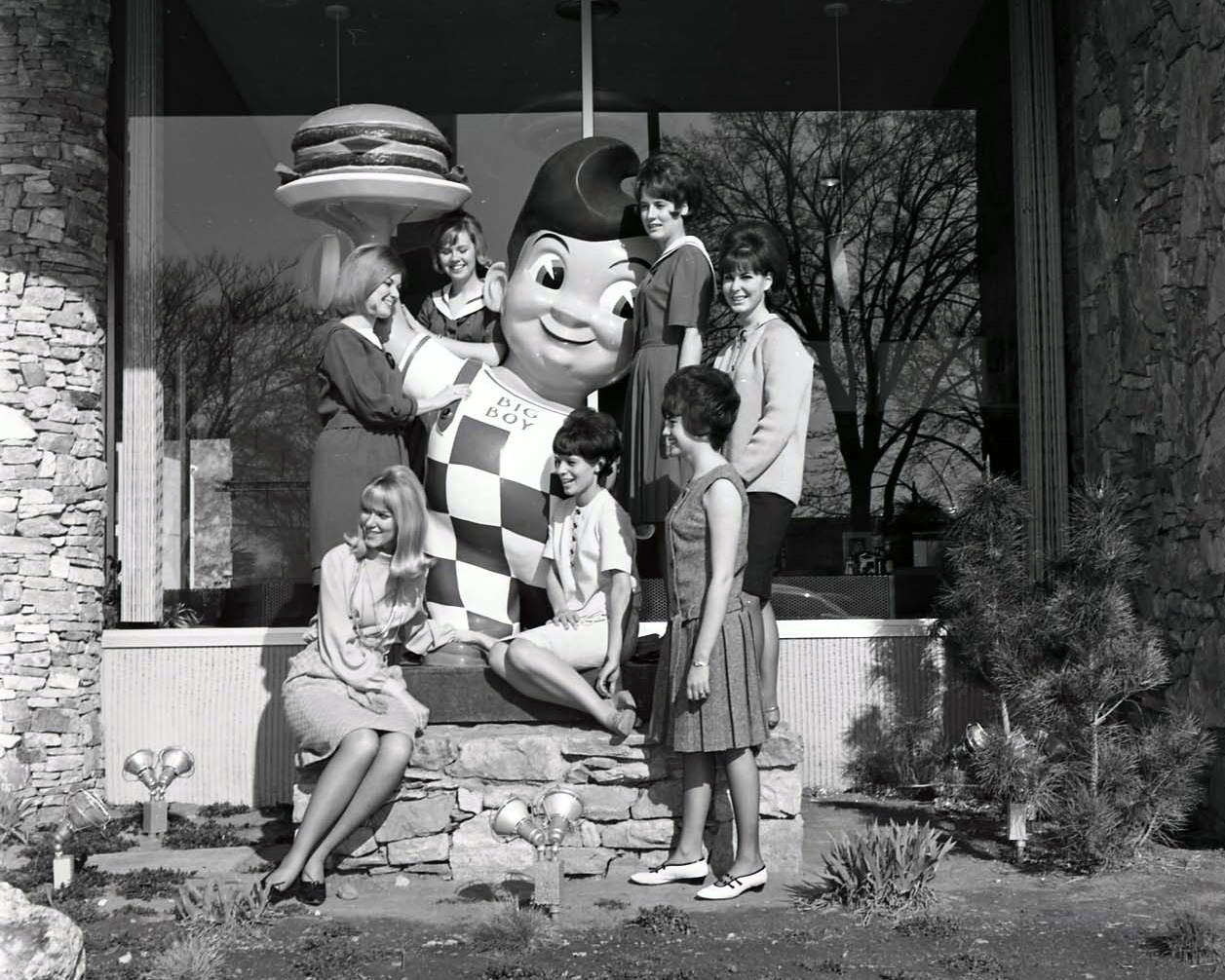 Seven girls posing with a Big Boy statue outside J.B. Big Boy Restaurant at 2132 Washington Blvd